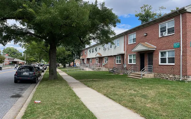 Two-story garden apartment buildings on a tree-lined street